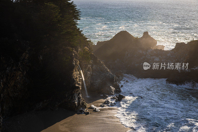 雄伟的瀑布在日落大Sur - Rocks和海洋美丽的阳光自然背景